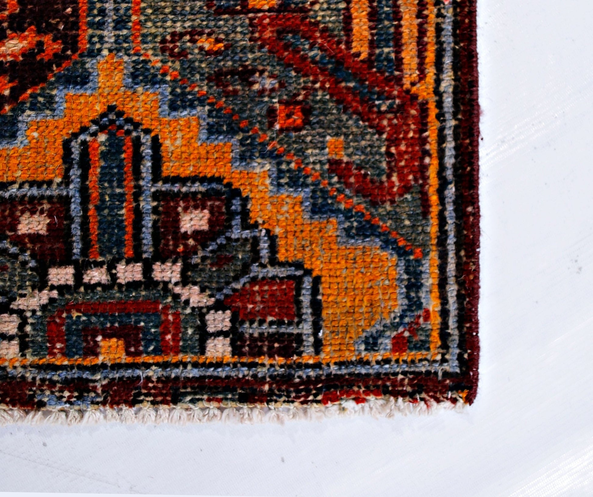 A close-up of a vintage Persian Bakhtiari rug featuring intricate geometric patterns in wool.