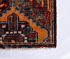 A close-up of a vintage Persian Bakhtiari rug featuring intricate geometric patterns in wool.