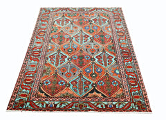 A vintage Persian Bakhtiari rug featuring a colorful geometric diamond pattern on a wool pile.