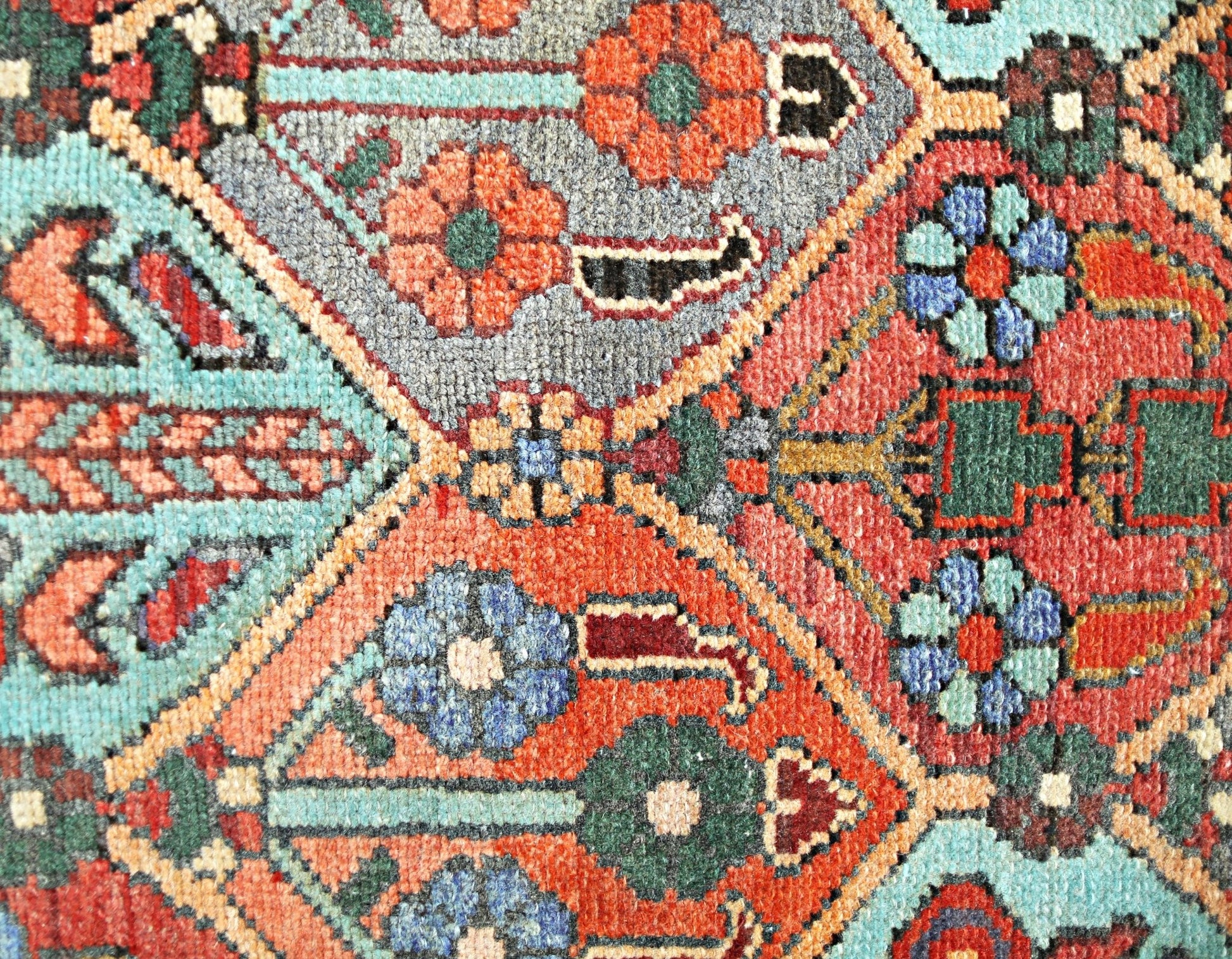 A close-up of a vintage Persian Bakhtiari rug featuring intricate floral patterns in vibrant colors.