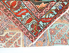 A folded vintage Persian Bakhtiari rug featuring intricate geometric patterns in vibrant colors.