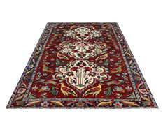 A vintage Persian Bakhtiari rug featuring a red field with bird and floral motifs.