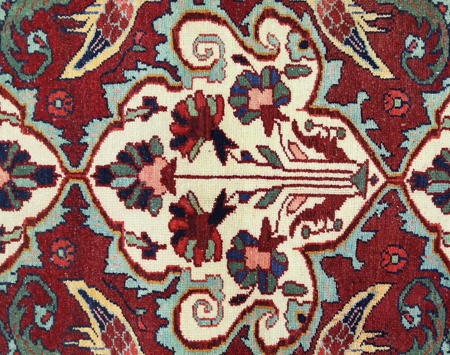 A vintage Persian Bakhtiari rug featuring a detailed floral pattern in red, cream, and blue tones.