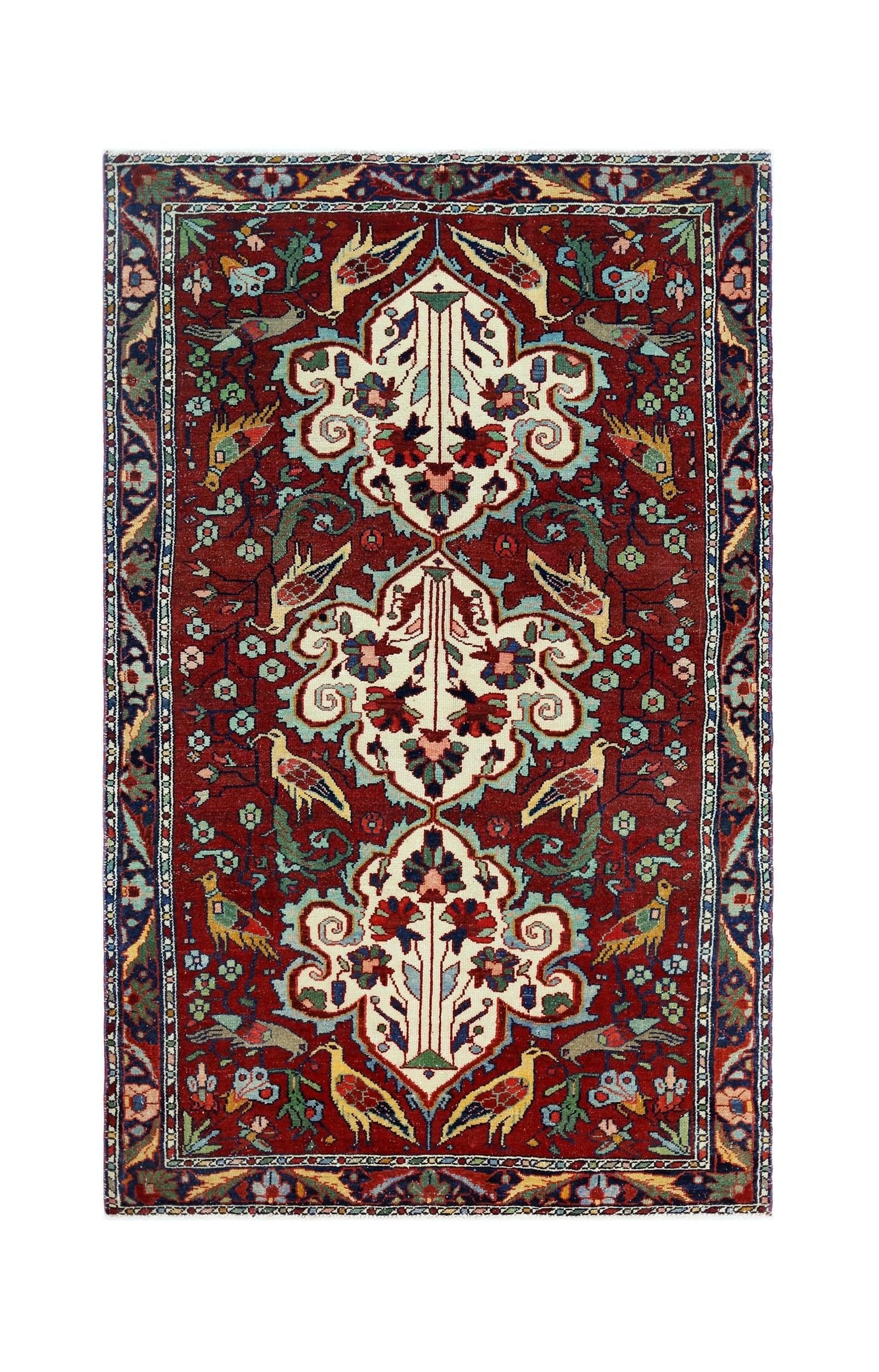 A vintage Persian Bakhtiari rug featuring a red field with floral motifs and bird patterns.