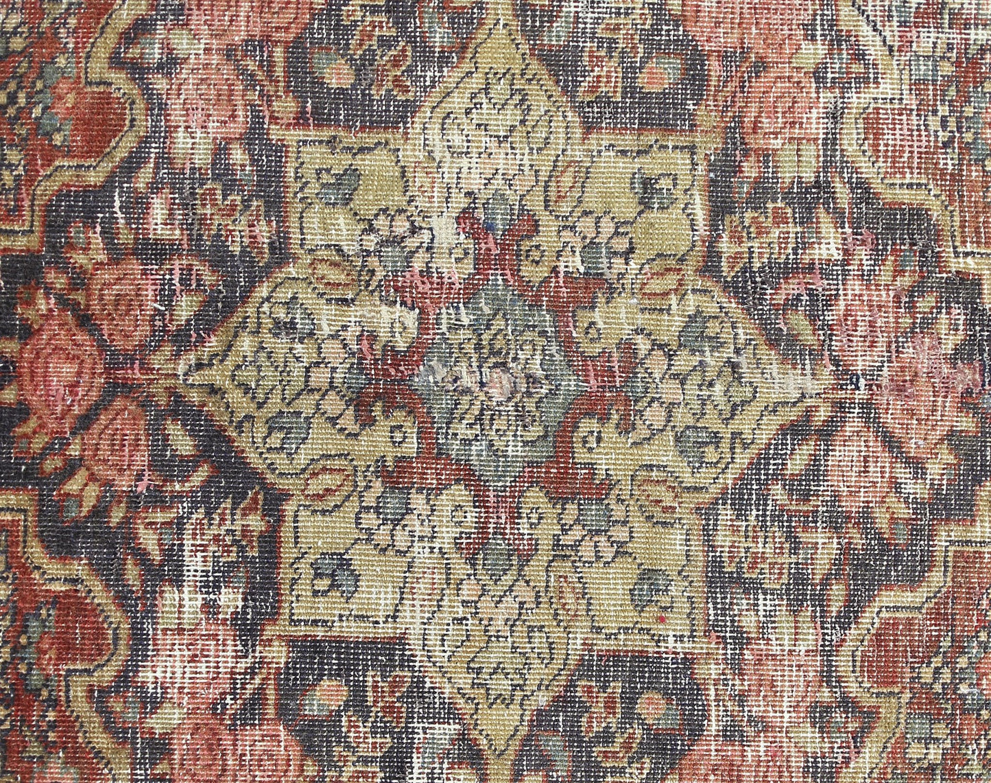 A vintage Persian Bakhtiari rug featuring a detailed floral medallion in muted red and olive tones.