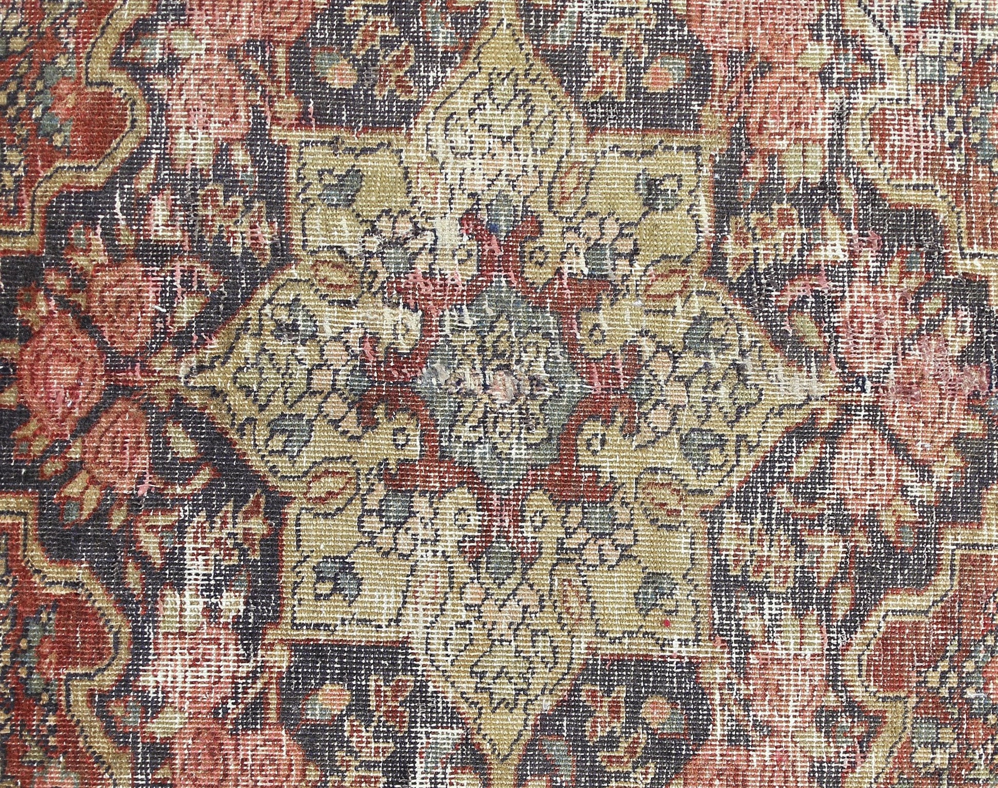 A vintage Persian Bakhtiari rug featuring a detailed floral medallion in muted red and olive tones.