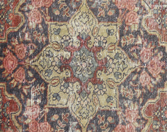 A vintage Persian Bakhtiari rug featuring a detailed floral medallion in muted red and olive tones.