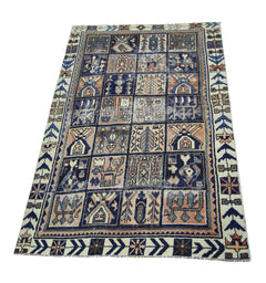 A vintage Persian Bakhtiari rug featuring a grid of geometric and floral motifs in blue and tan.