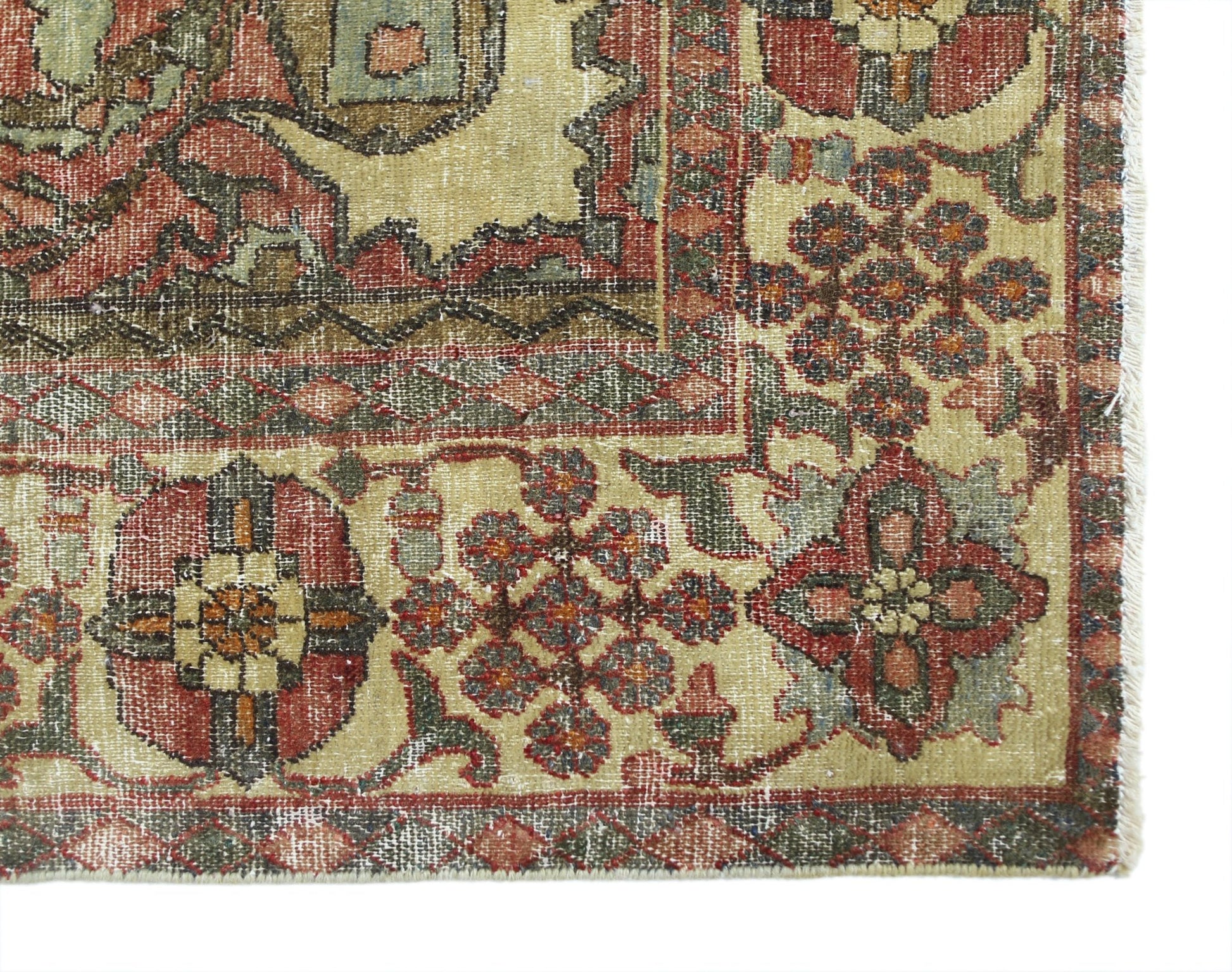 A vintage Persian Bakhtiari rug featuring intricate floral patterns in red, green, and cream tones.