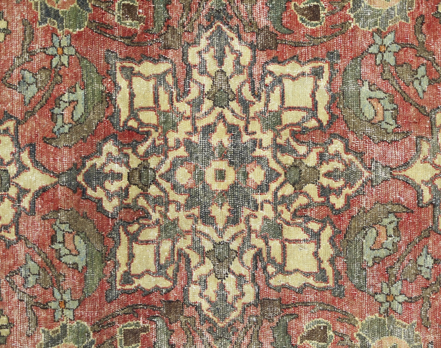 A vintage Persian Bakhtiari rug featuring a detailed geometric floral pattern in red and green.