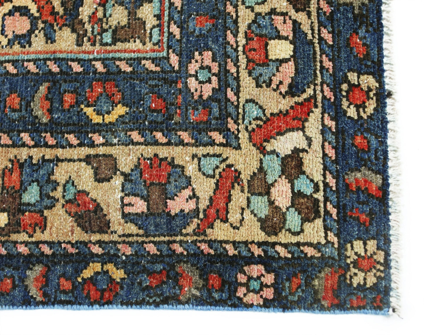 A corner detail of a vintage Persian Bakhtiari rug featuring intricate floral patterns in wool.