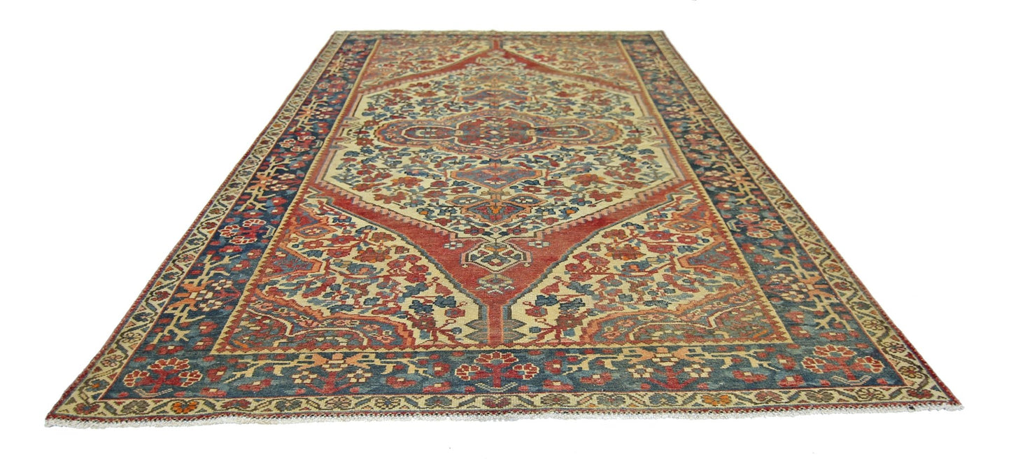 A vintage Persian Bakhtiari rug featuring a central medallion on a red and cream floral field.