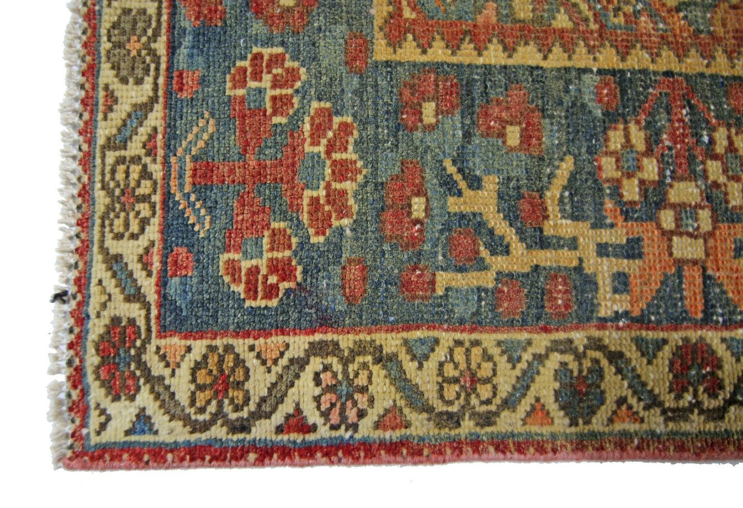A corner view of a vintage Persian Bakhtiari rug featuring intricate floral patterns in wool.
