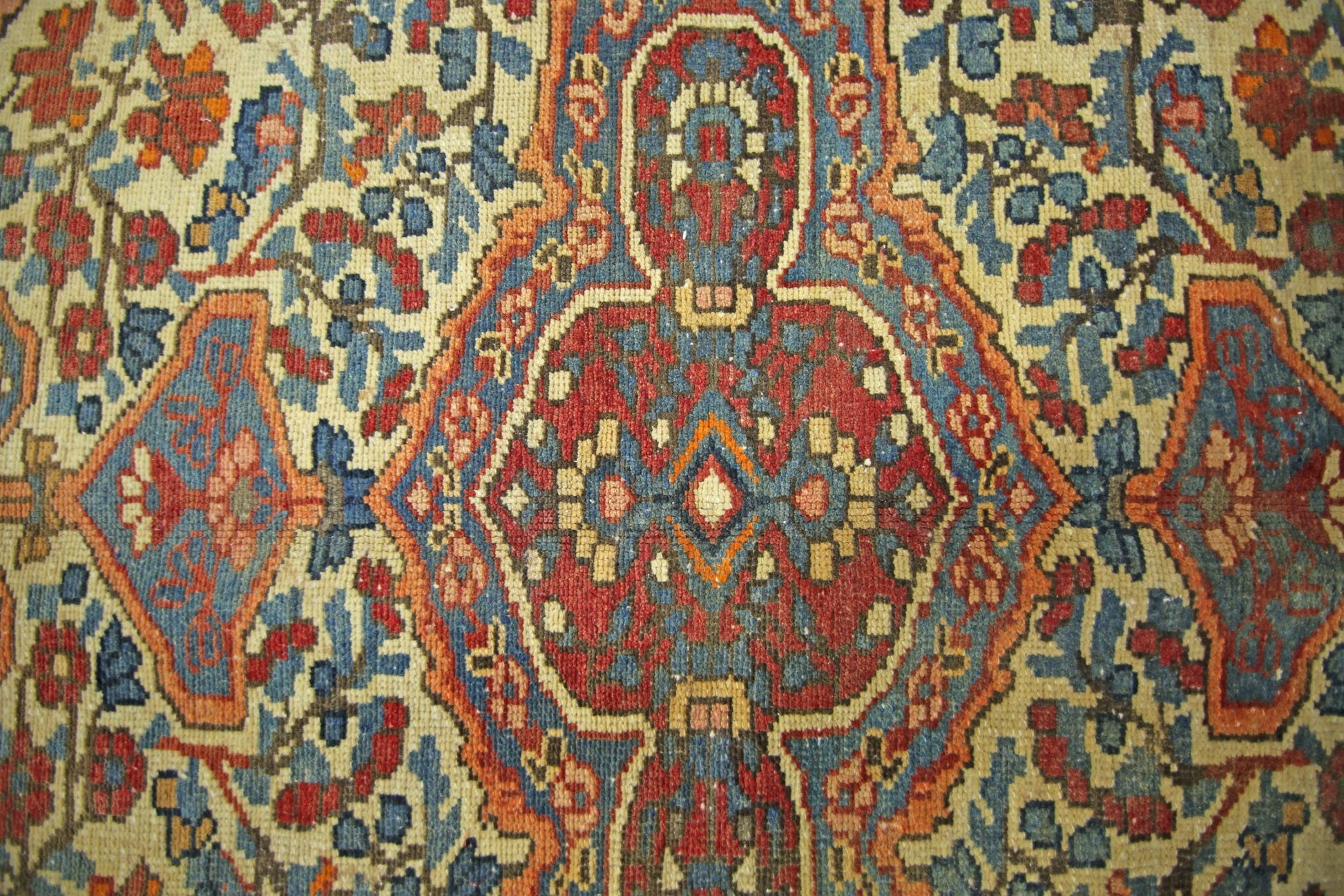 A vintage Persian Bakhtiari rug featuring a geometric floral pattern in red, blue, and cream.