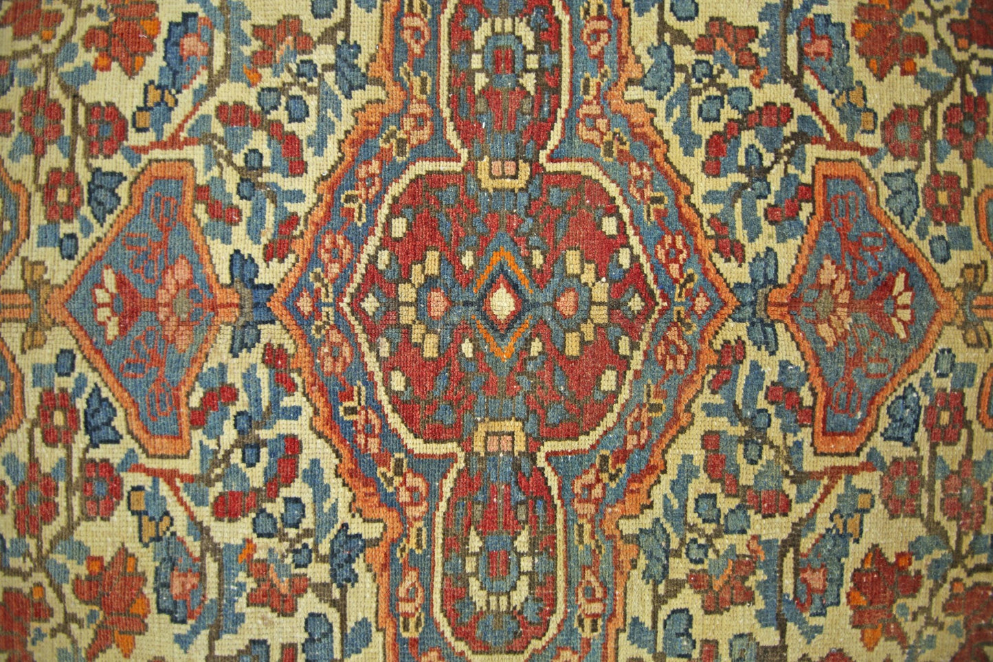 A vintage Persian Bakhtiari rug featuring a geometric floral pattern in red, blue, and cream.