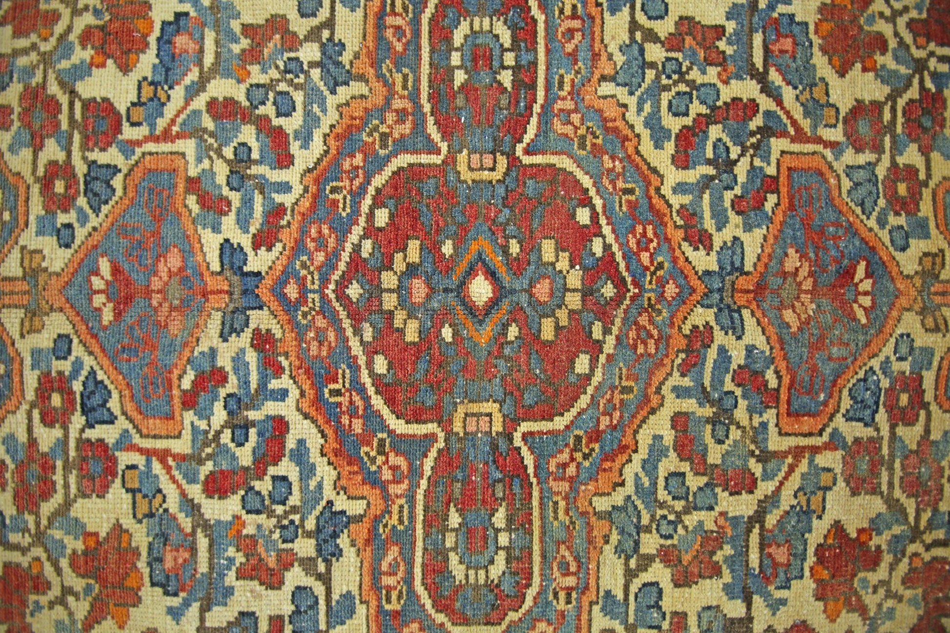 A vintage Persian Bakhtiari rug featuring a geometric floral pattern in red, blue, and cream.