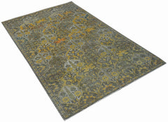 A vintage Persian Bakhtiari rug featuring a distressed floral pattern in yellow, grey, and brown.