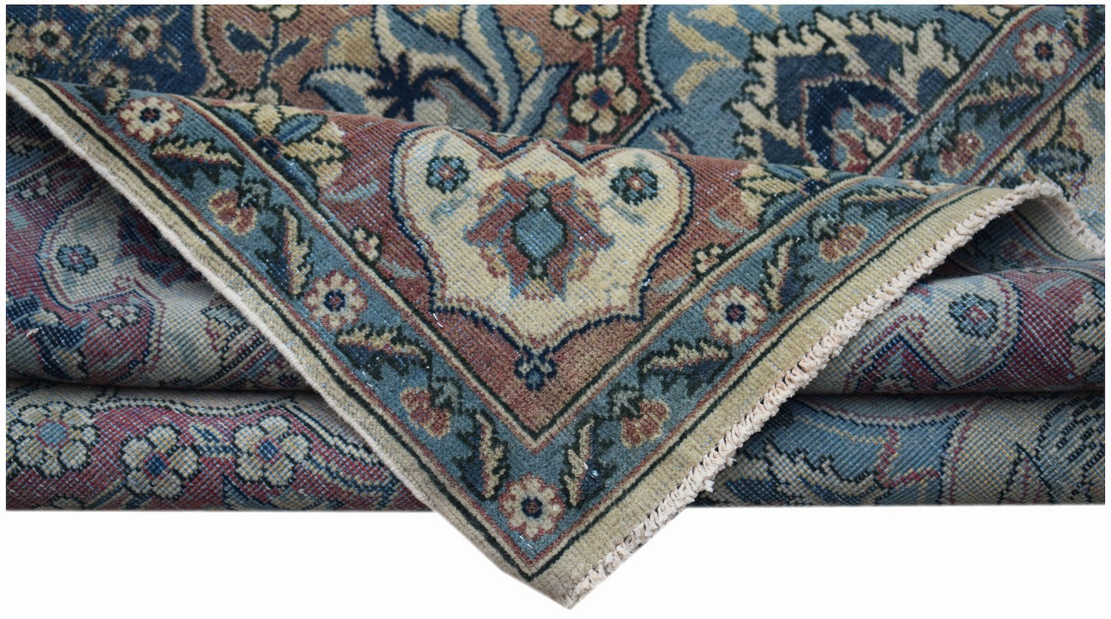 A folded vintage Persian Bakhtiari rug featuring intricate floral patterns in blue and red tones.