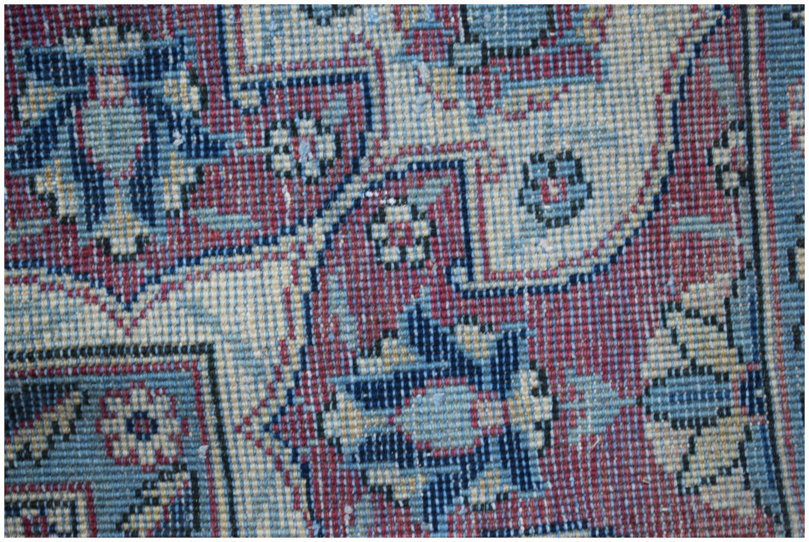 A close-up of a vintage Persian Bakhtiari rug featuring intricate floral patterns in blue and red.