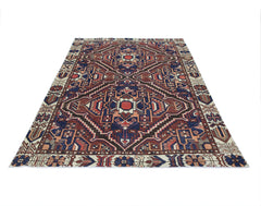 A vintage Persian Bakhtiari rug featuring a geometric medallion pattern in red, blue, and cream.