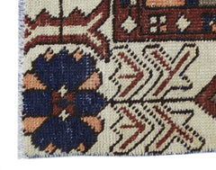 A close-up of a vintage Persian Bakhtiari rug featuring intricate floral patterns in wool.