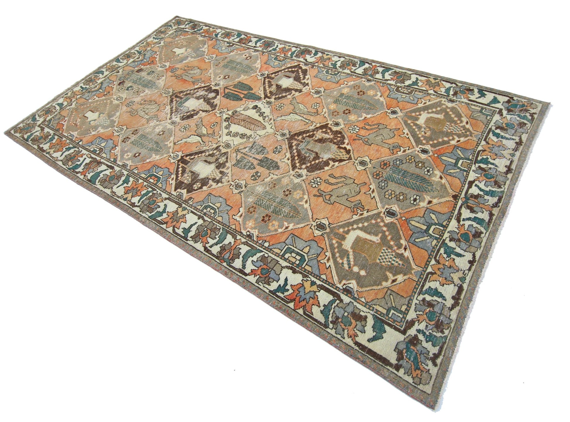 A vintage handmade Persian Bakhtiari rug featuring a geometric diamond pattern in orange and blue.