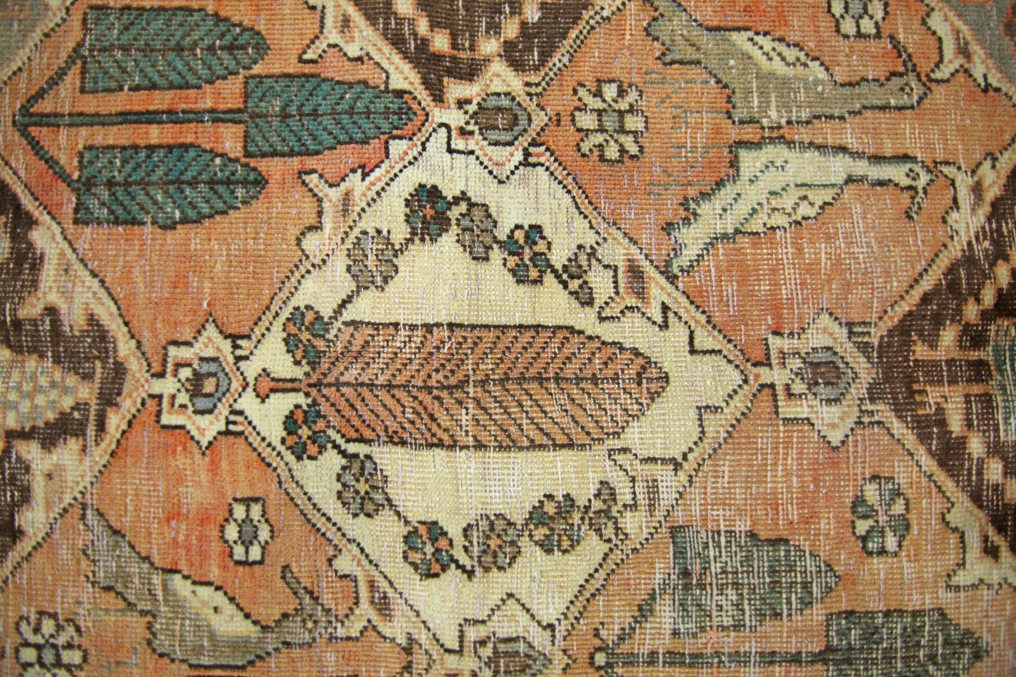 A vintage Persian Bakhtiari rug featuring a central leaf motif within a diamond-shaped medallion.