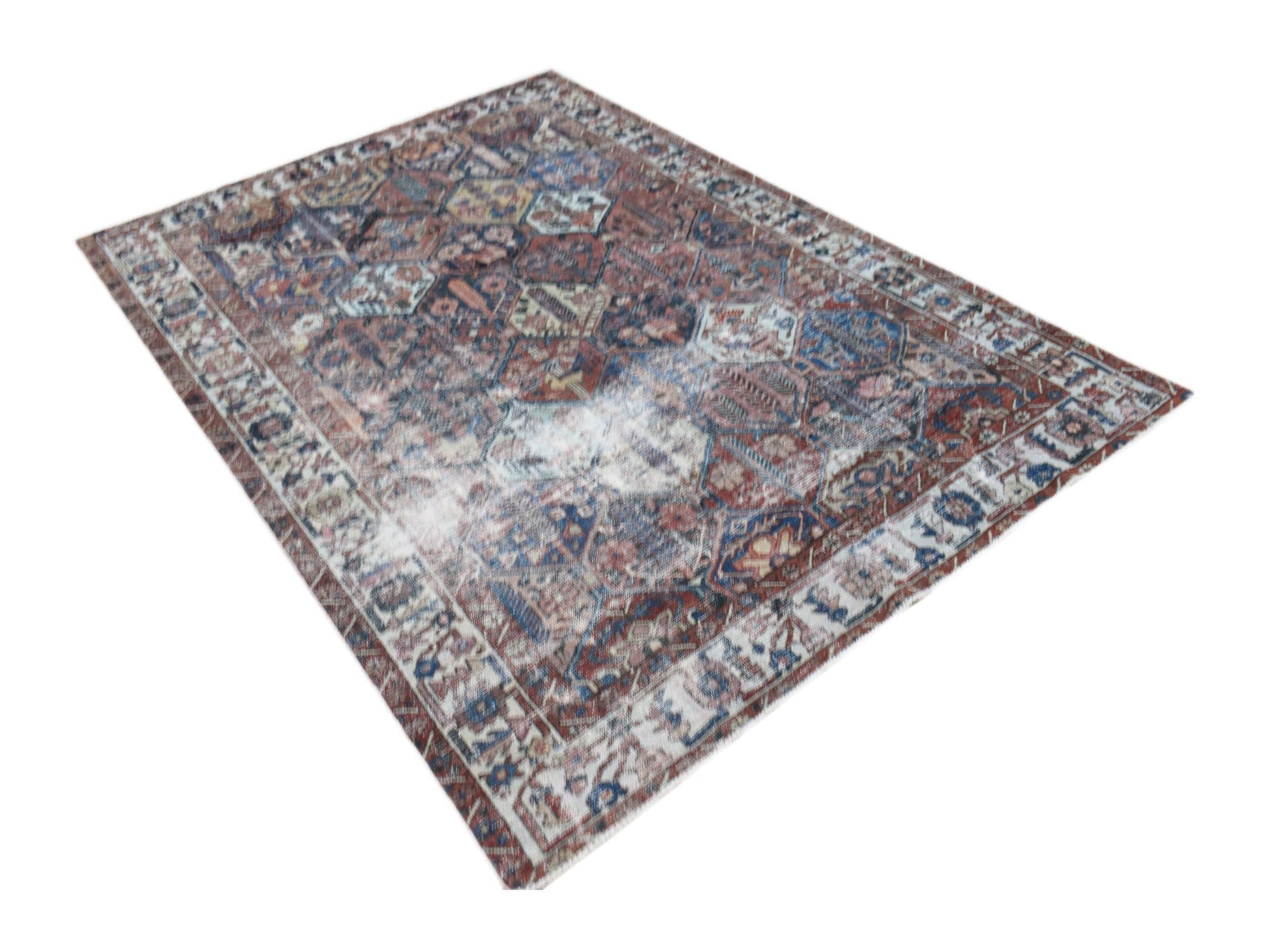 A vintage Persian Bakhtiari rug featuring a distressed, multi-colored geometric pattern.