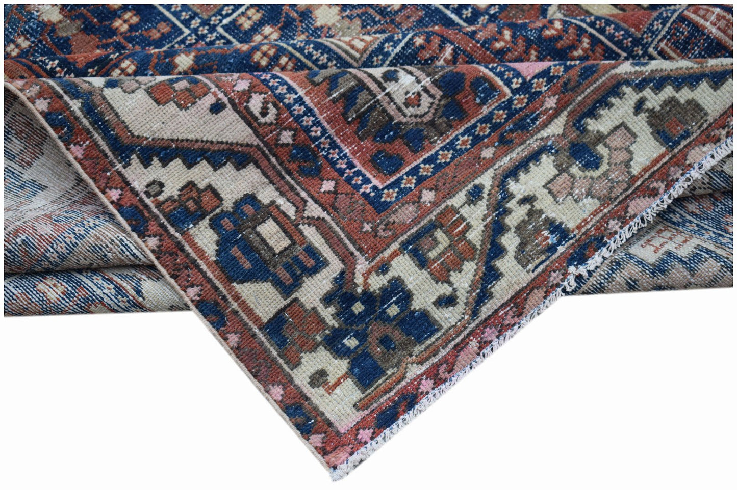A vintage Persian Bakhtiari rug featuring a geometric pattern in blue, cream, and terracotta tones.