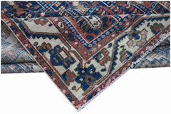 A vintage Persian Bakhtiari rug featuring a geometric pattern in blue, cream, and terracotta tones.