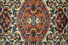 A vintage Persian Bakhtiari rug featuring a geometric central medallion in red, blue, and cream.