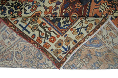 A corner of a vintage Persian Bakhtiari rug is folded back to show its intricate floral pattern.