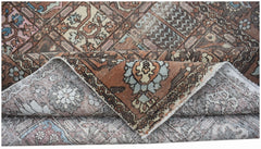 A vintage Persian Bakhtiari rug featuring a geometric pattern in muted brown, blue, and cream tones.
