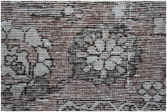 A vintage Persian Bakhtiari rug featuring intricate floral patterns in muted earth tones.