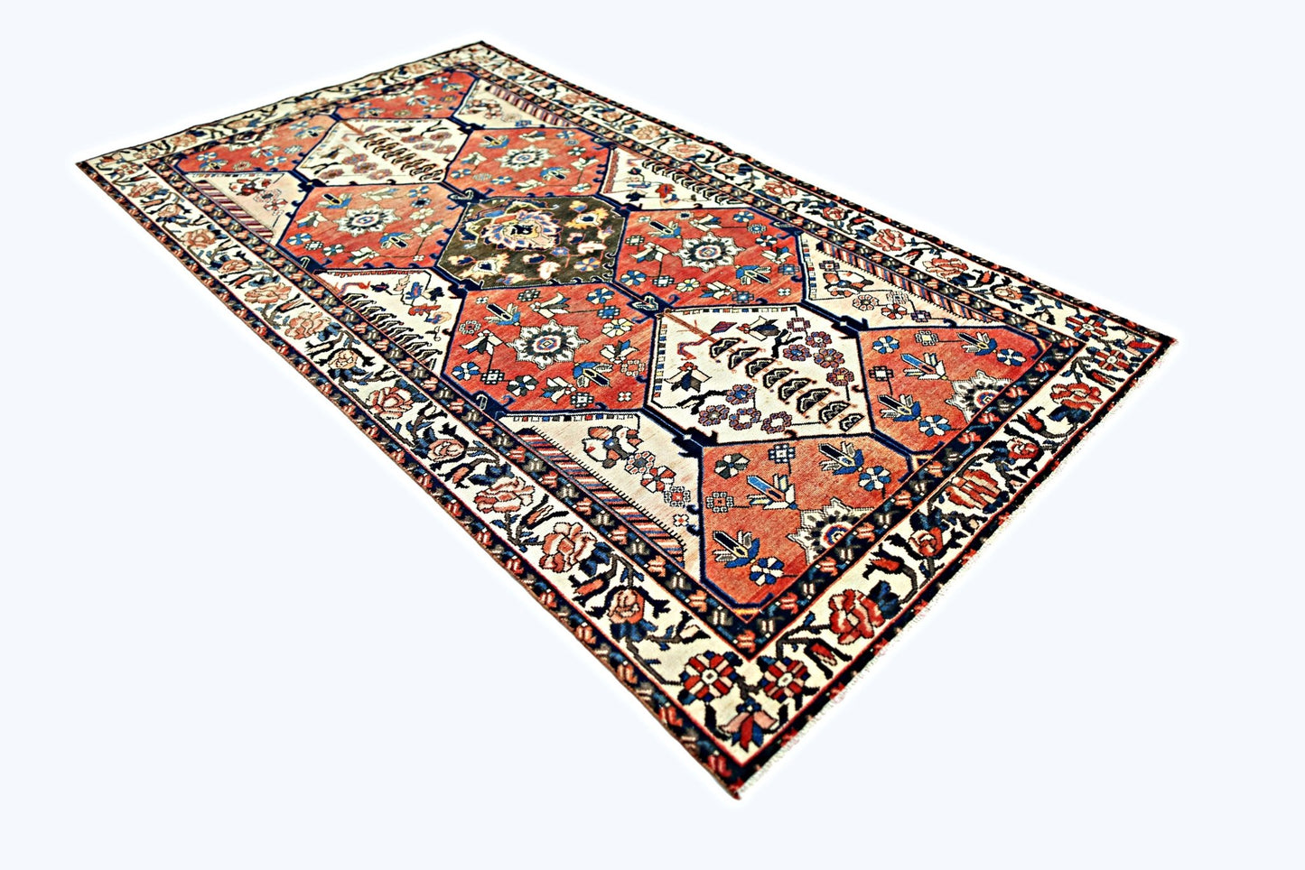 A vintage Persian Bakhtiari rug featuring a geometric garden design in red, blue, and cream tones.