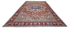 A vintage Persian Tabriz rug featuring a central floral medallion on a rust and cream background.