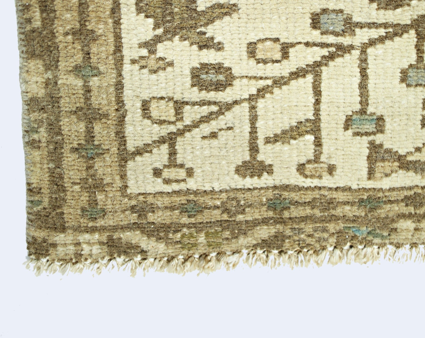 A close-up of a vintage Persian Bakhtiari runner featuring a geometric pattern in neutral tones.