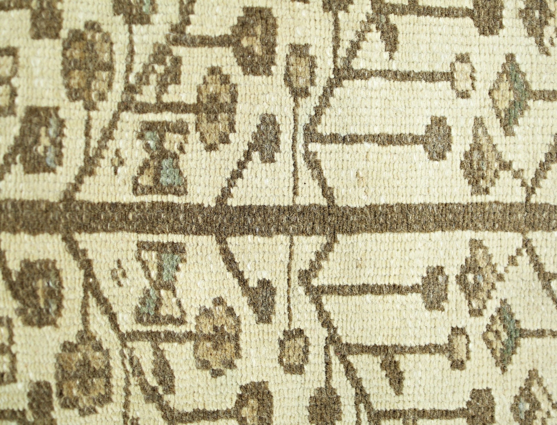 A close-up of a vintage Persian Bakhtiari runner featuring a geometric floral pattern in brown.