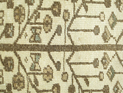A close-up of a vintage Persian Bakhtiari runner featuring a geometric floral pattern in brown.