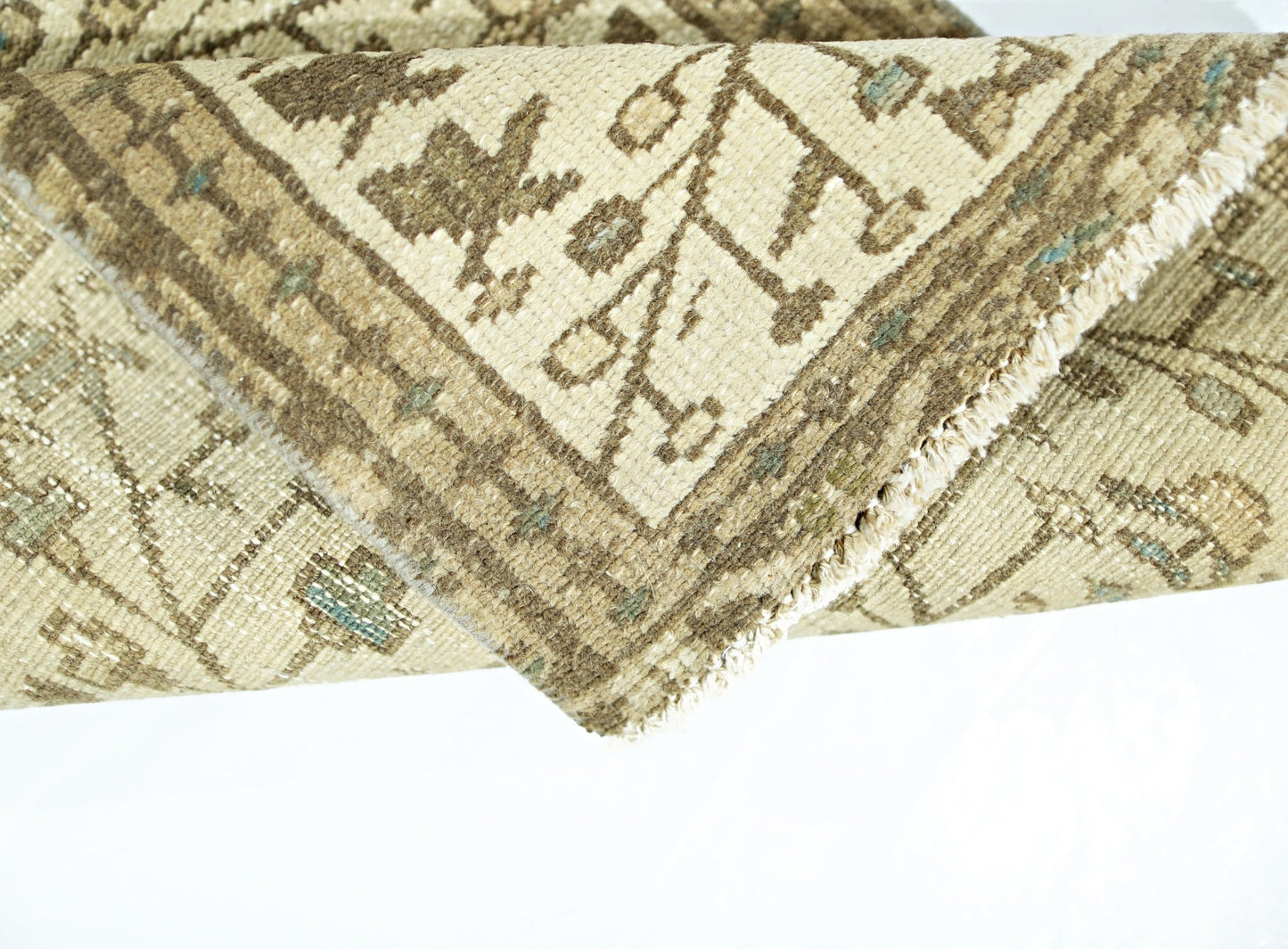 A folded vintage Persian Bakhtiari runner featuring a beige wool pattern on a cotton base.