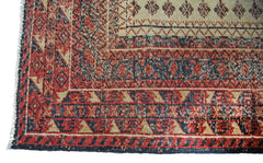 A vintage Persian Bakhtiari runner featuring intricate geometric patterns in red, blue, and cream.