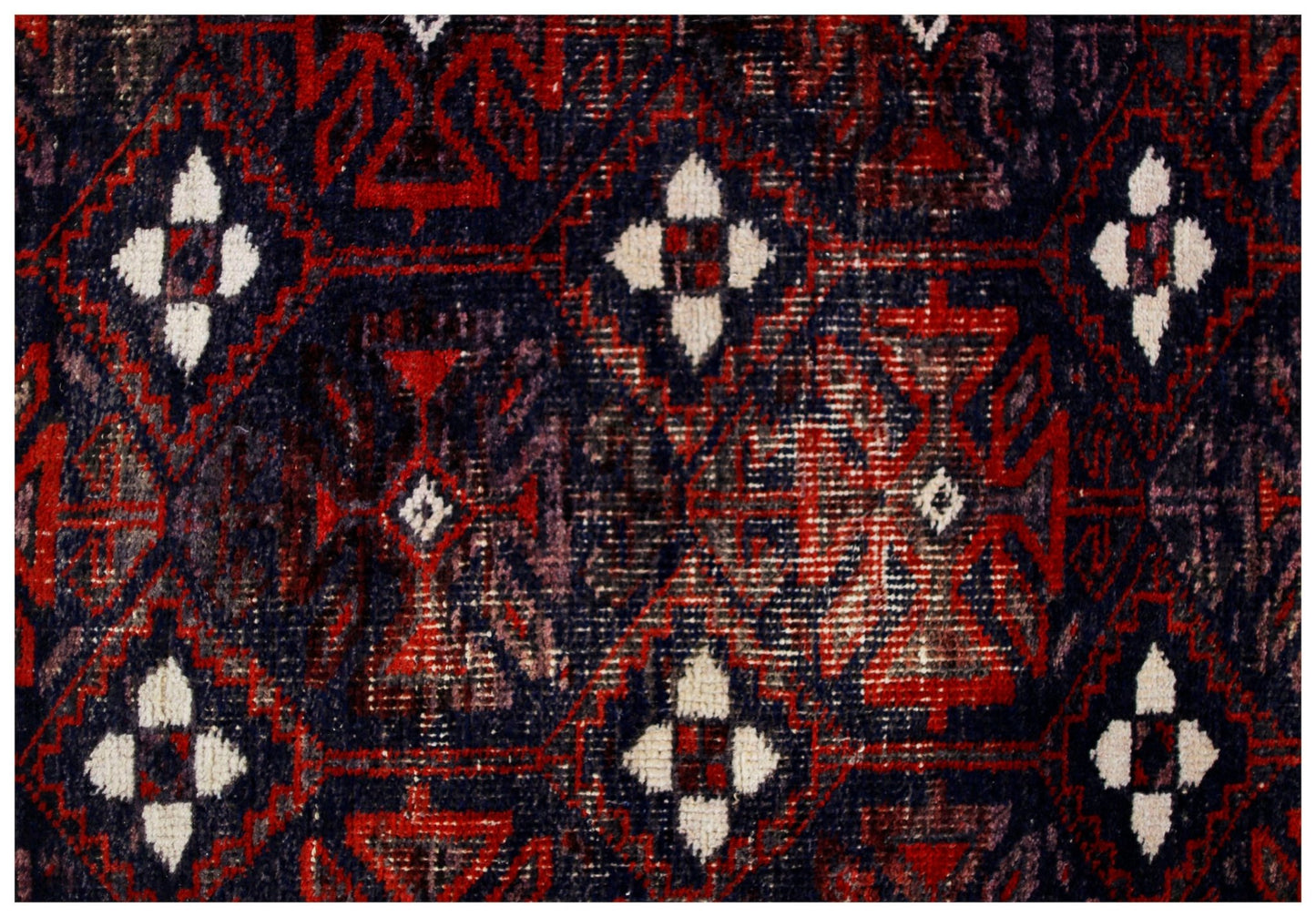 A vintage Afghan Baluch rug featuring a repeating geometric pattern in deep red and dark blue.