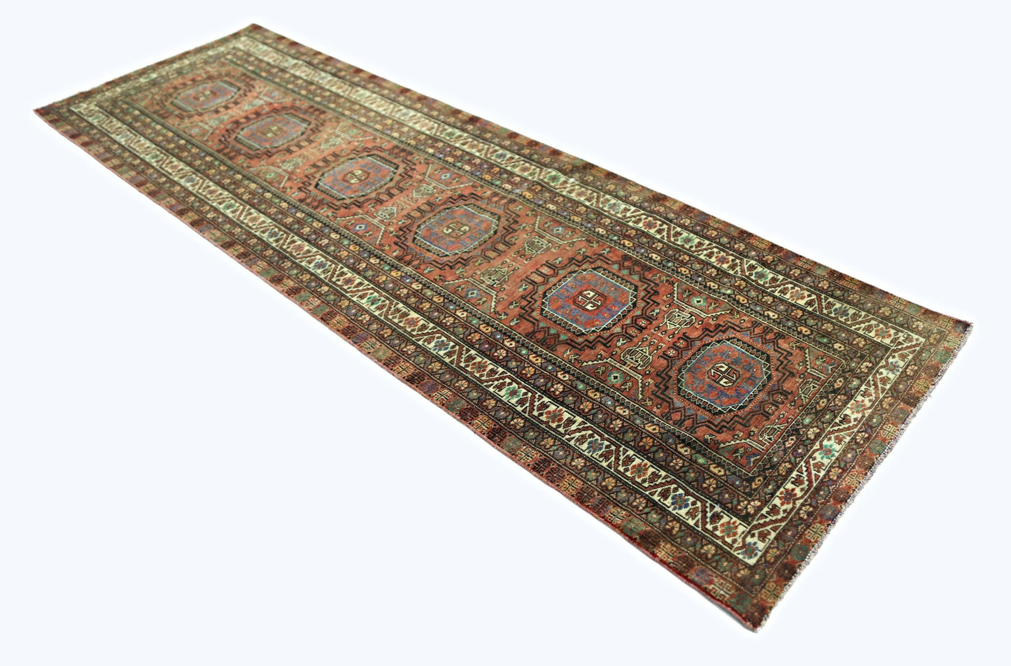 A vintage Persian Baluch runner featuring geometric medallions in a warm, multi-colored palette.