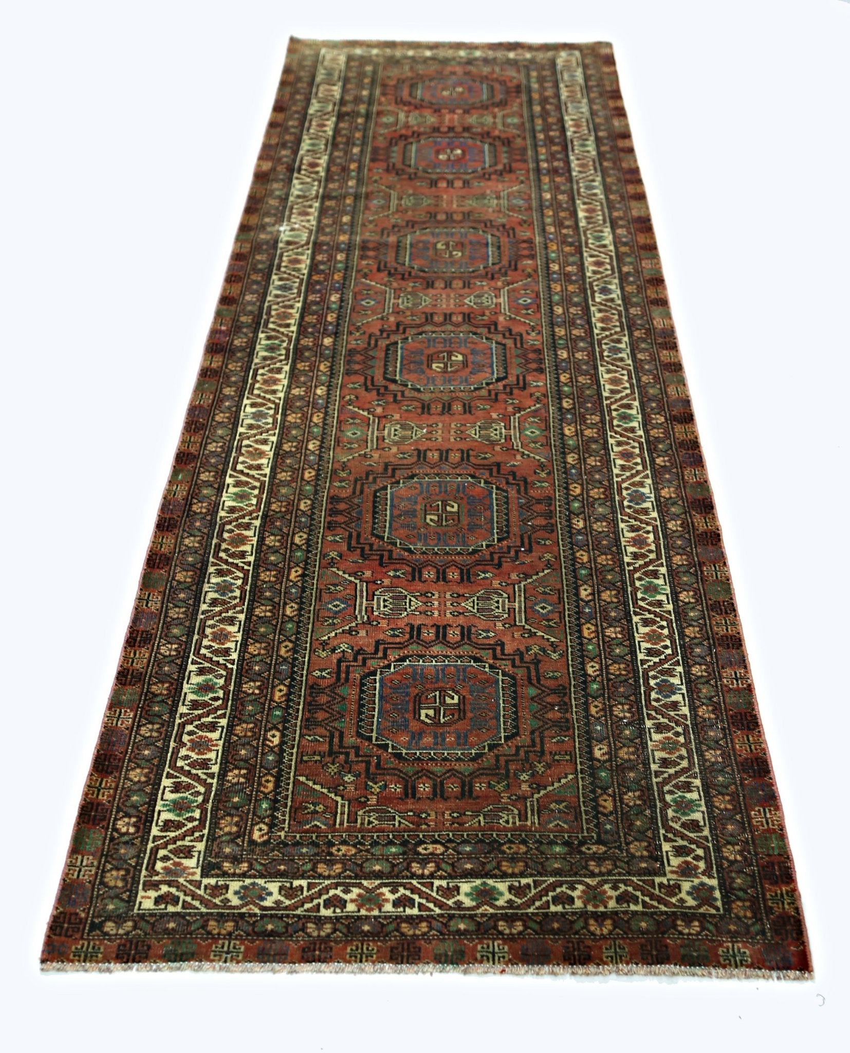 A vintage Persian Baluch runner featuring a geometric pattern in red, blue, and cream tones.