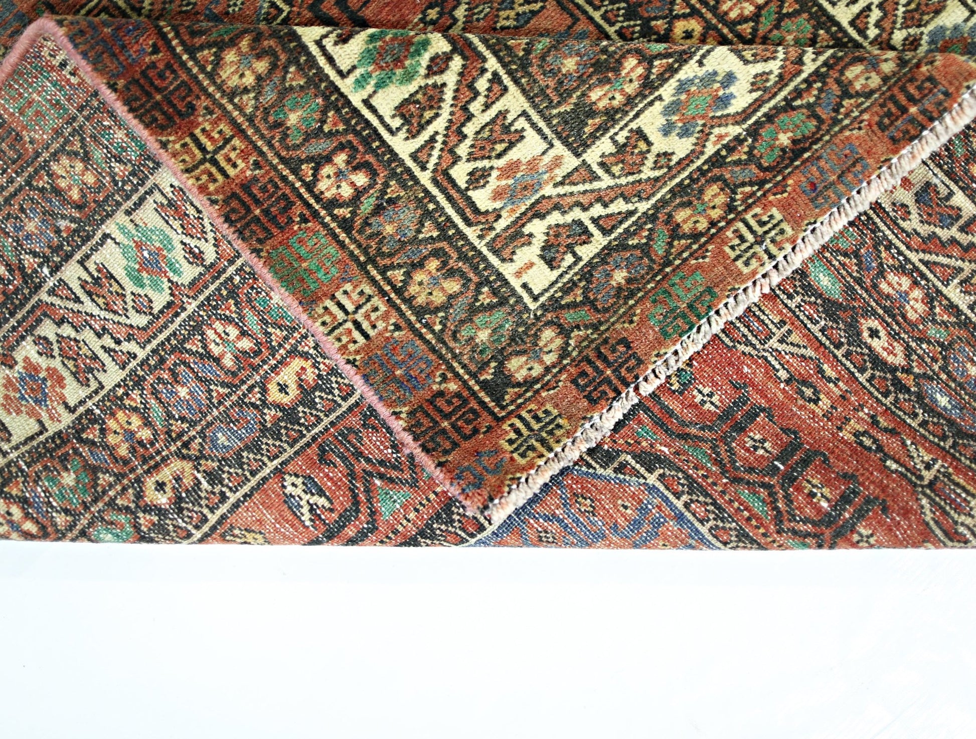 A vintage Persian Baluch runner featuring intricate geometric patterns in a rich, colorful palette.