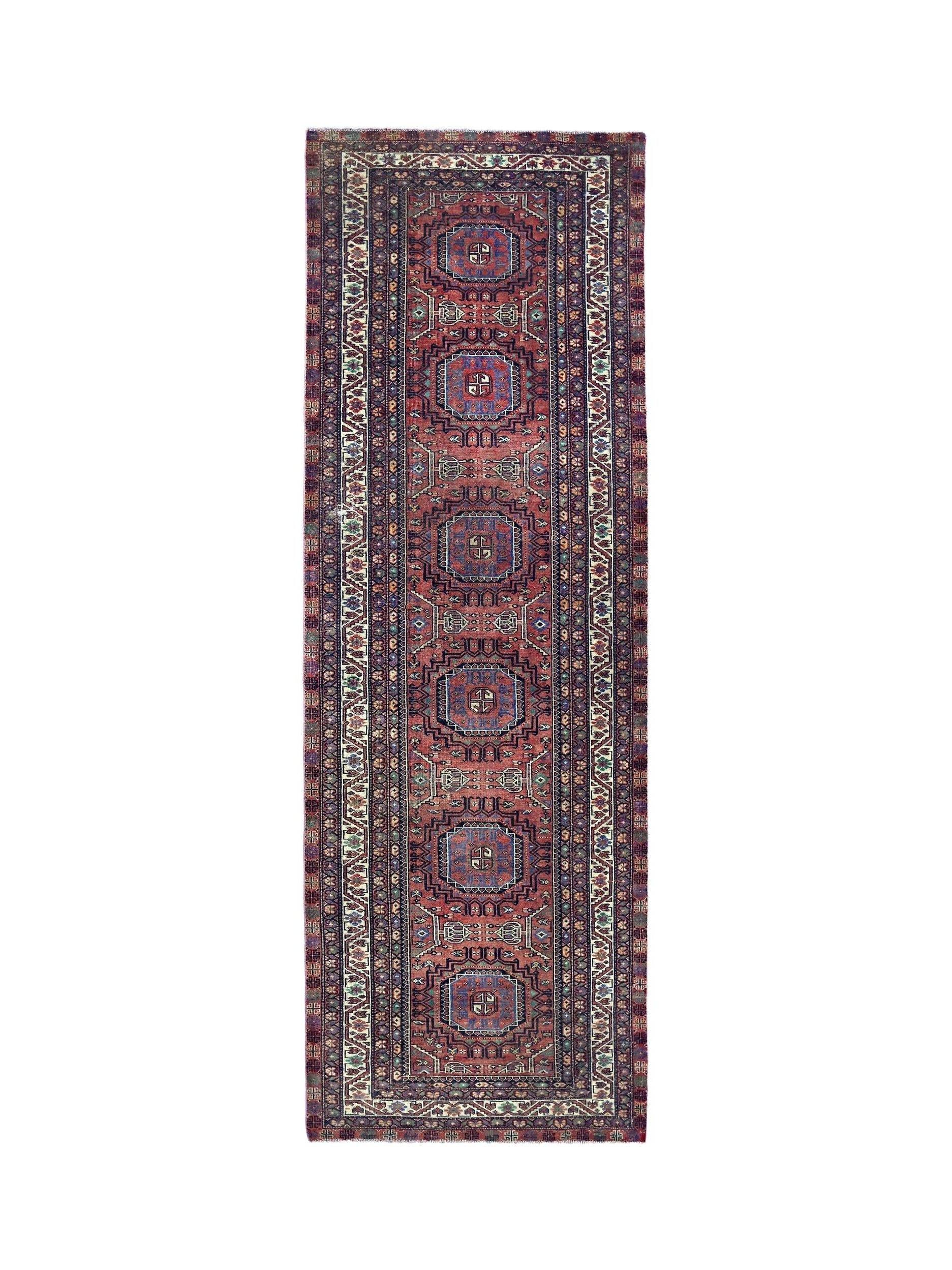 A vintage Persian Baluch runner featuring a repeating geometric medallion pattern in red and blue.