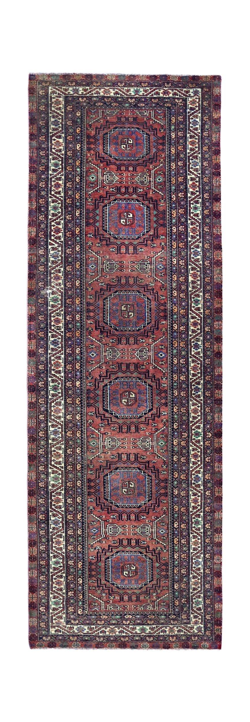A vintage Persian Baluch runner featuring a repeating geometric medallion pattern in red and blue.