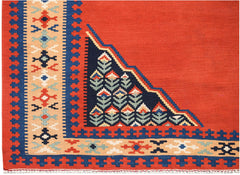 A vintage Persian kilim featuring a geometric floral pattern in red, blue, and beige wool.