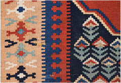 A close-up of a handmade Persian kilim featuring geometric patterns in red, blue, and beige wool.