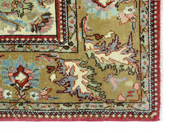 A vintage Persian Bidjar rug featuring intricate floral patterns in muted tones on a tan field.